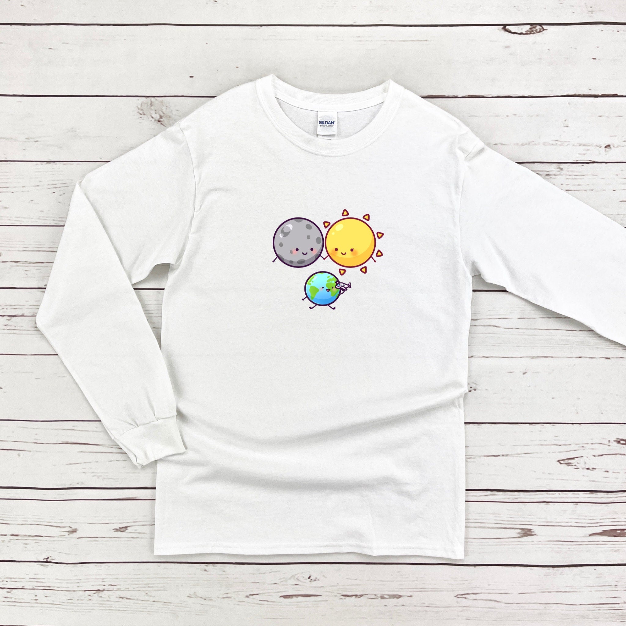 a white long - sleeved shirt with a picture of the sun, moon and