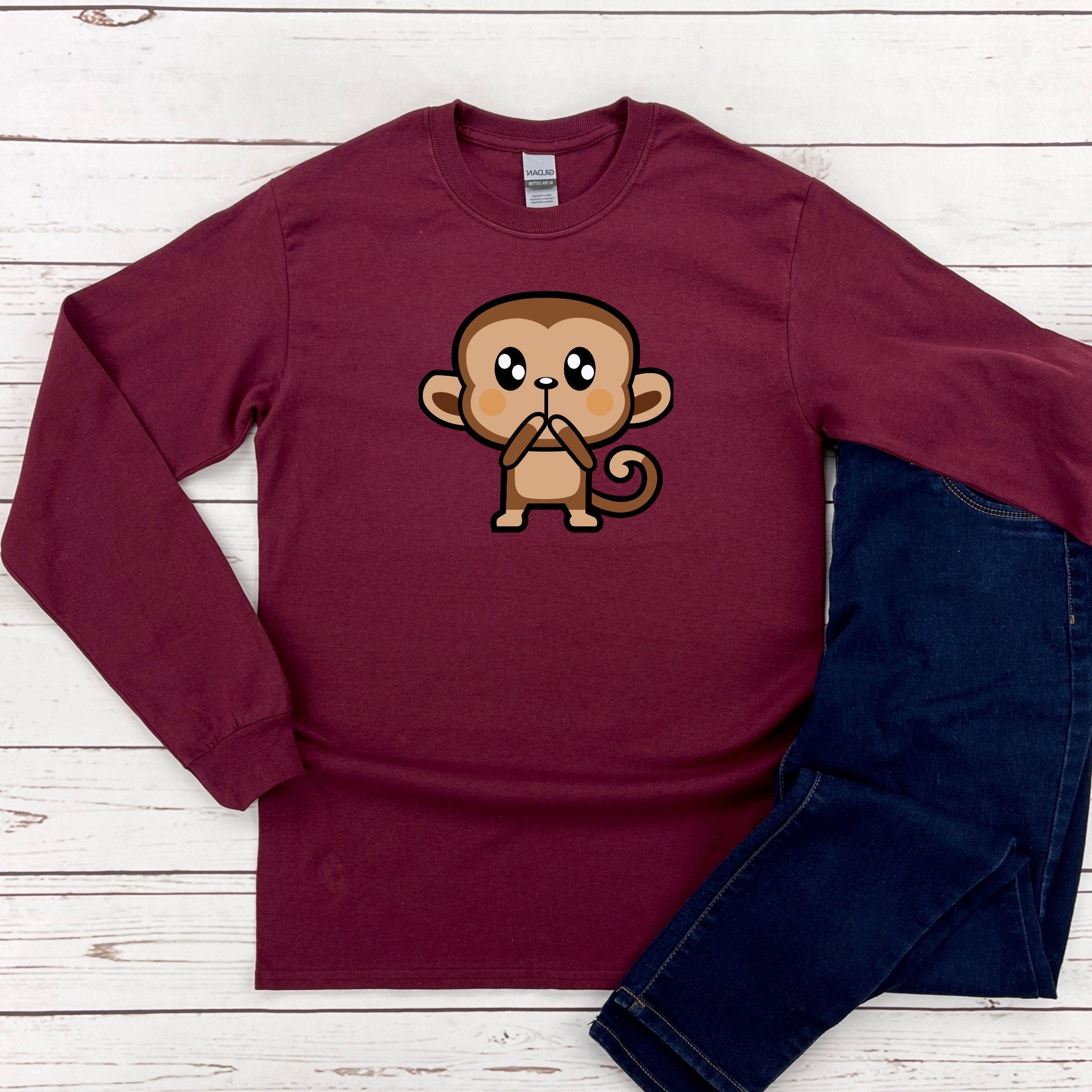 a maroon shirt with a cartoon monkey on it