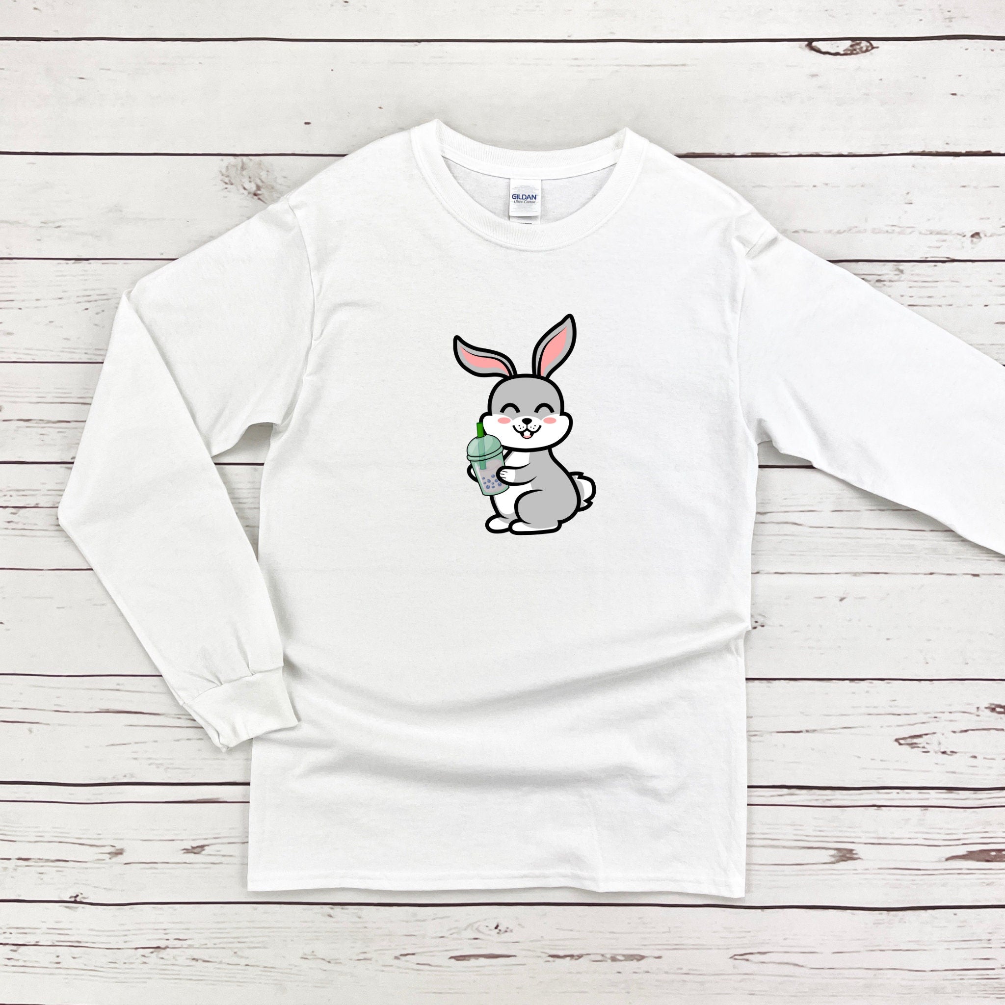 a white shirt with a bunny holding a carrot