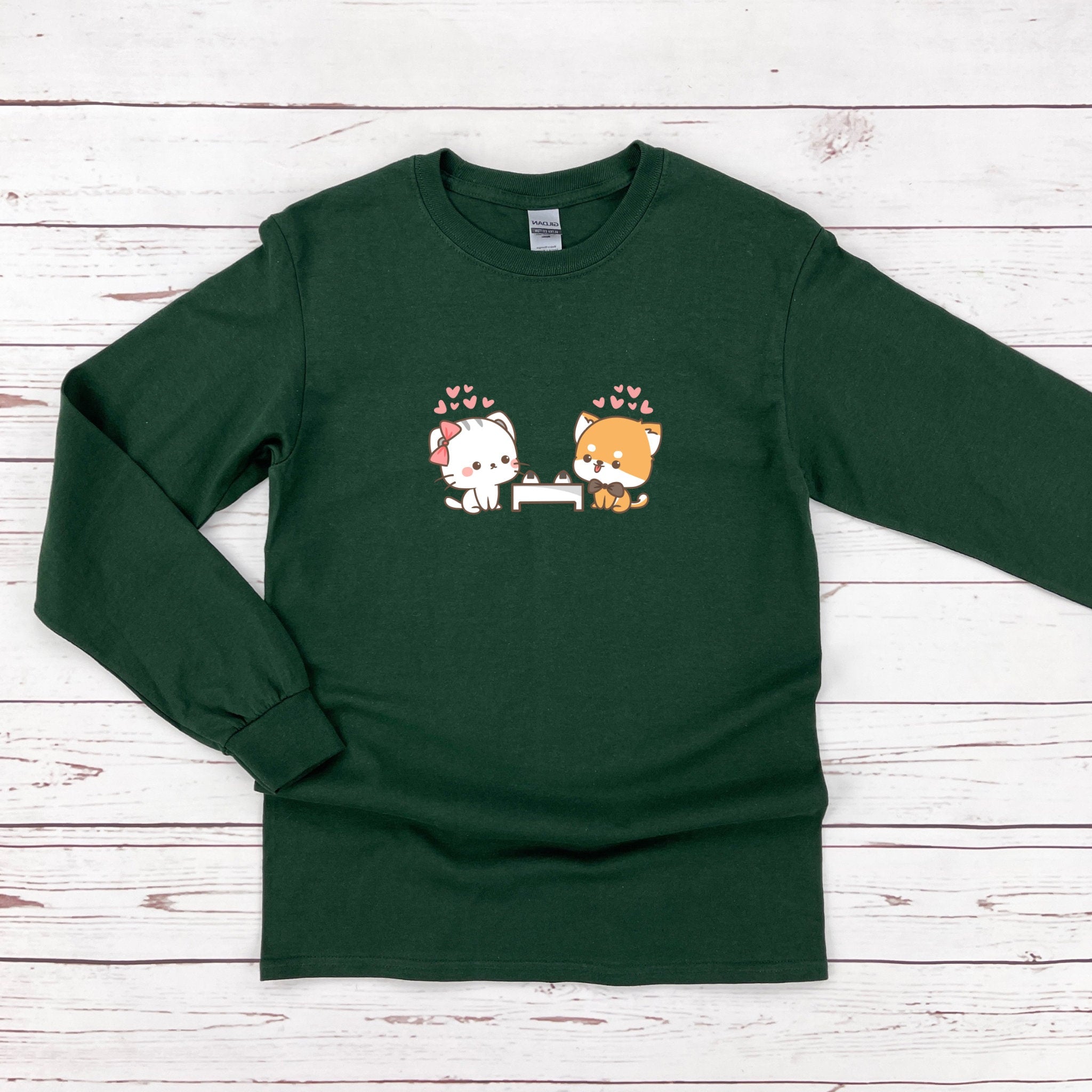 a green shirt with two cats on it