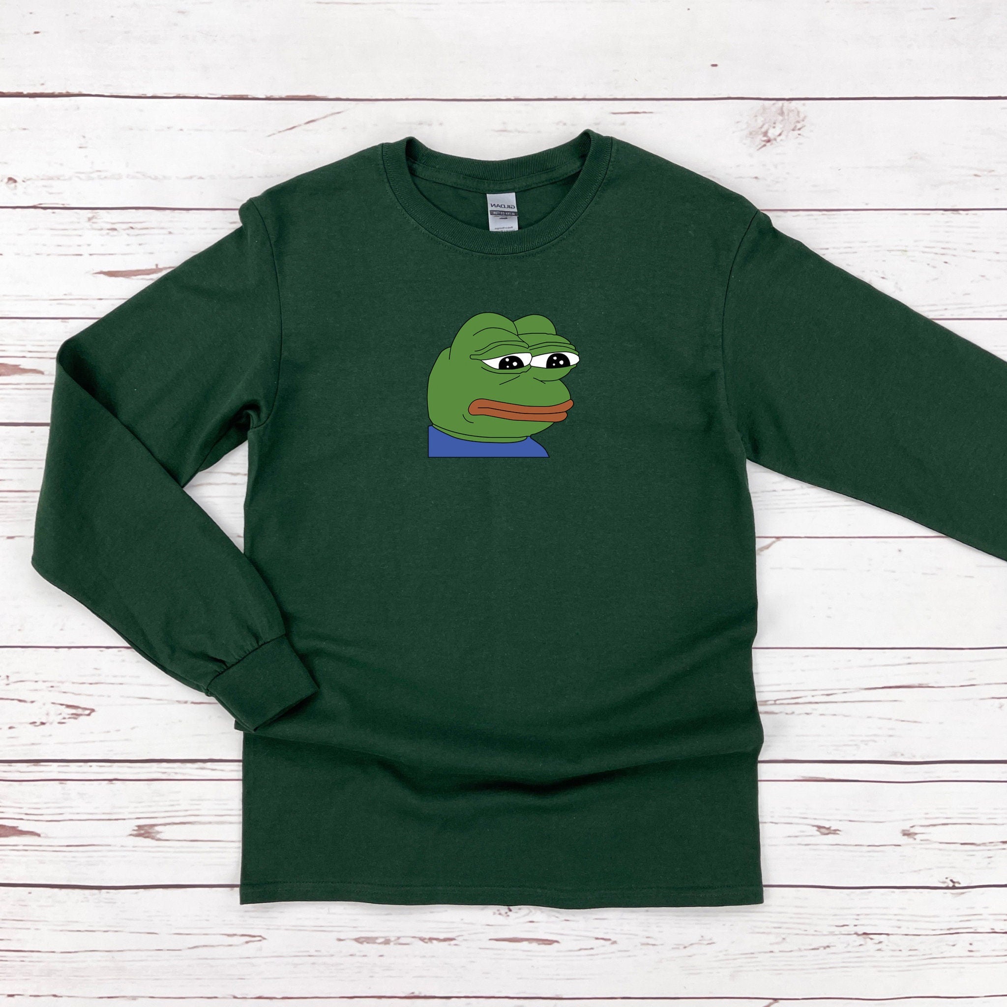 a green shirt with a cartoon frog on it