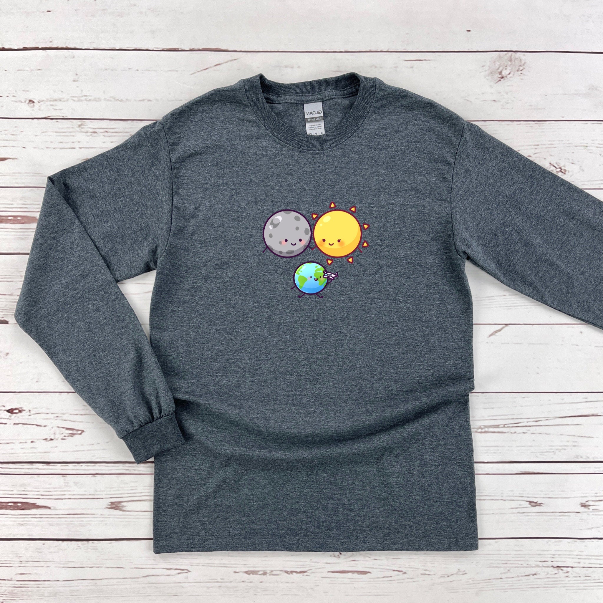 a gray long sleeve shirt with an image of the earth and sun on it