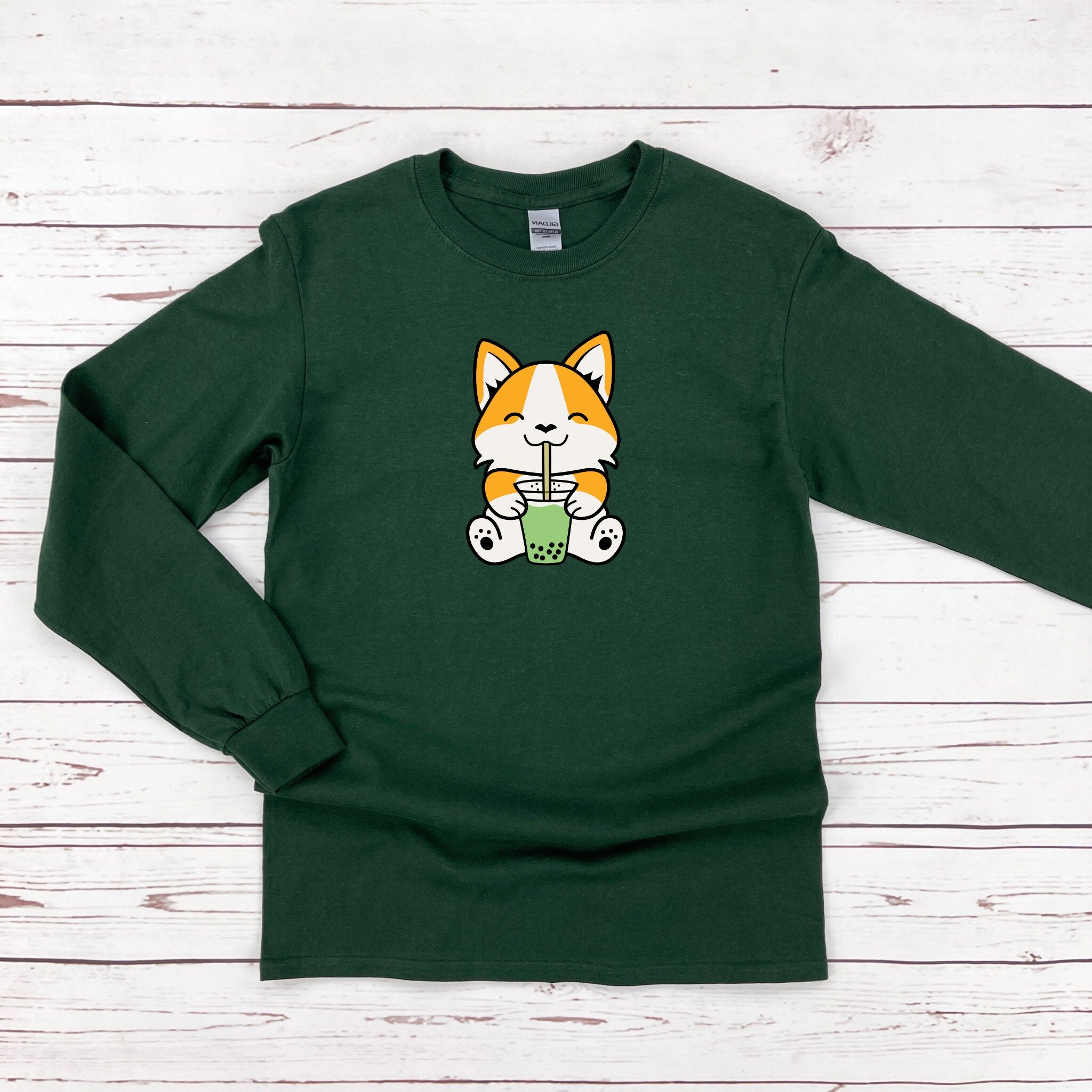 a green shirt with a cat holding a cup of coffee
