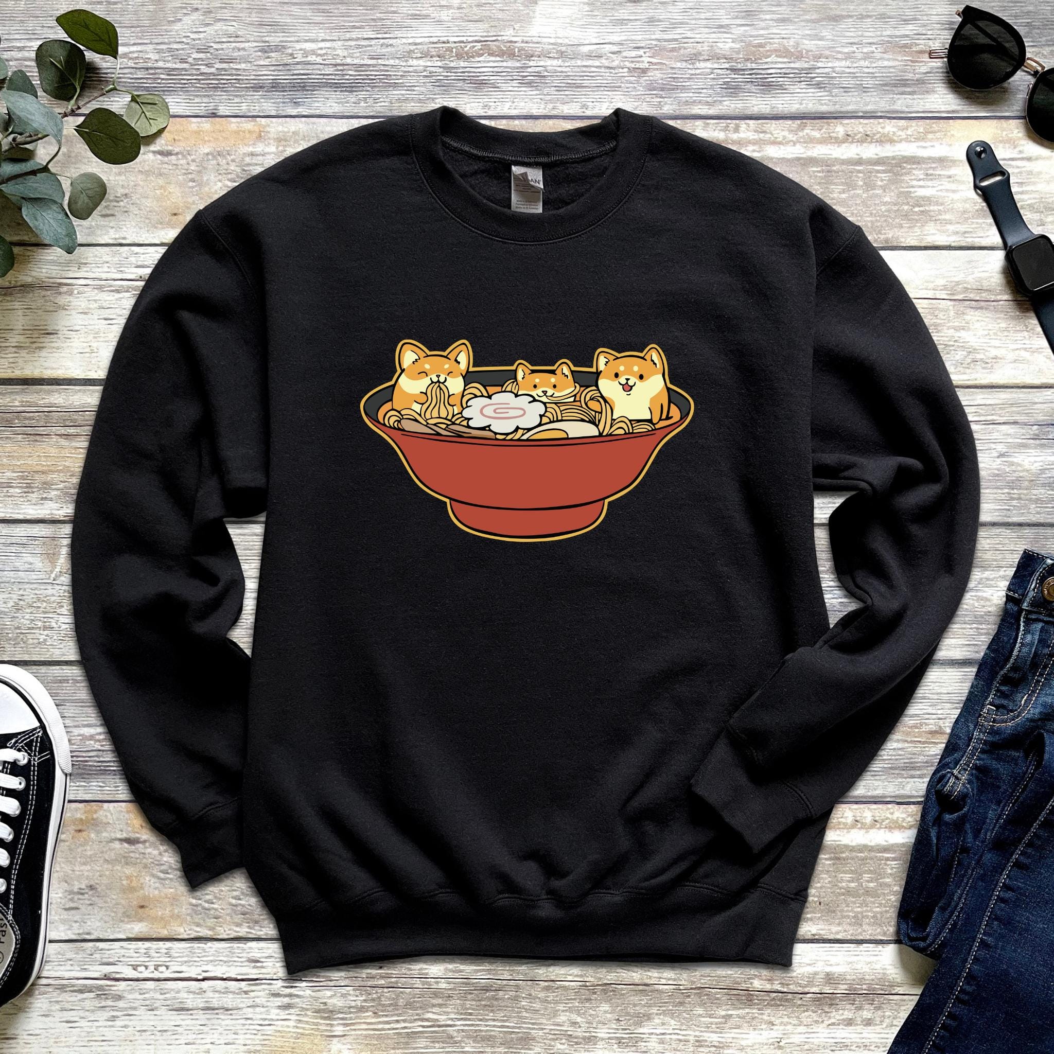 a black sweater with a picture of two cats in a bowl