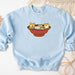 a blue sweatshirt with cats in a bowl on it