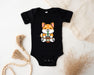 a baby bodysuit with a picture of a fox holding a drink