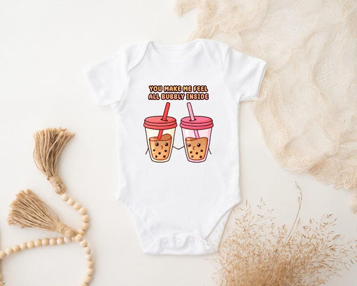 a baby bodysuit with two cups of iced coffee