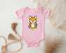a pink baby bodysuit with a picture of a corgi eating cereal