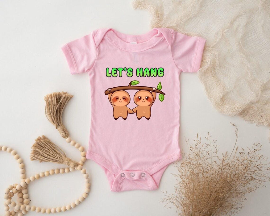 a pink baby bodysuit with two slots on it