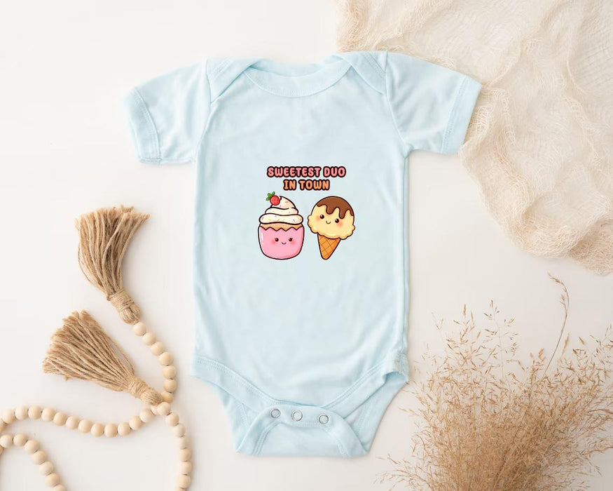 a baby bodysuit with a picture of a cupcake and a strawberry on it