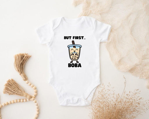 a baby bodysuit that says but first boba