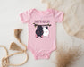 a baby bodysuit with a picture of a dog hanging on a clothes line