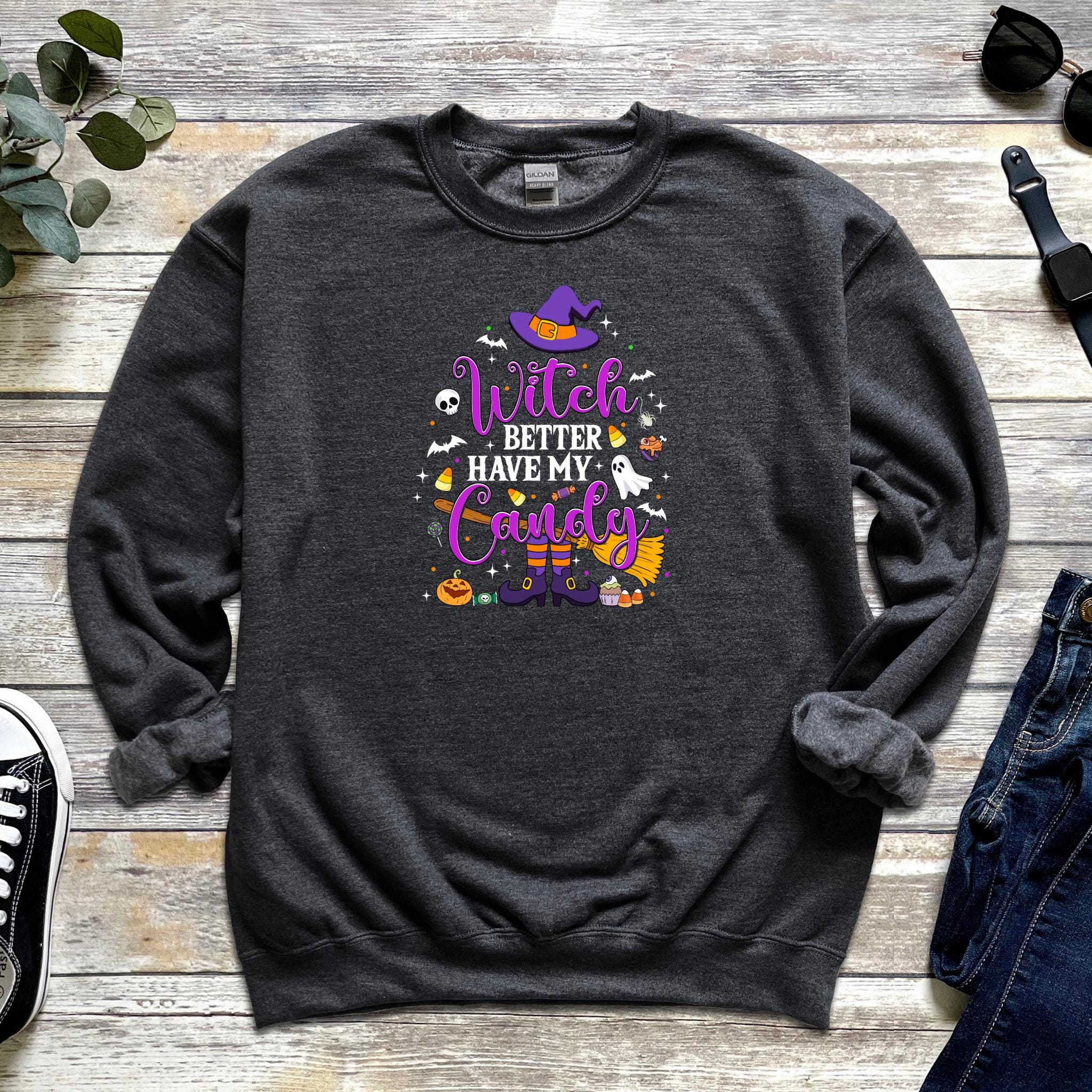 a sweatshirt with witch saying on it next to a pair of jeans