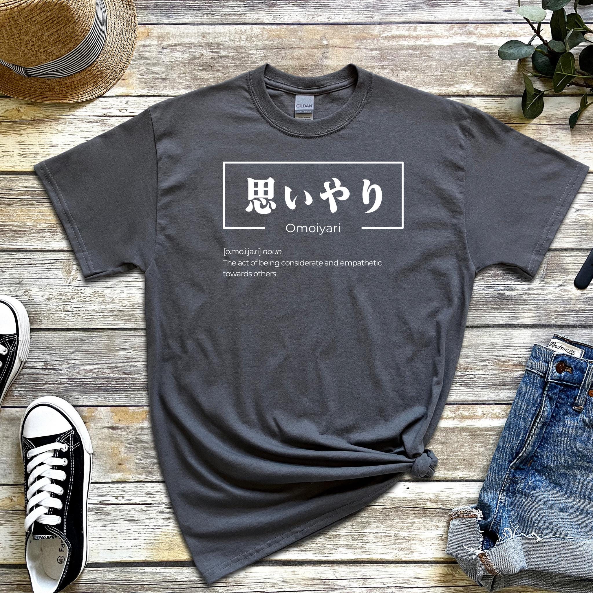 a t - shirt with a japanese writing on it next to a pair of jeans