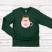 a green shirt with a cat in a cup on it