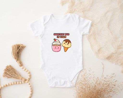 a baby bodysuit with a cupcake and a donut on it