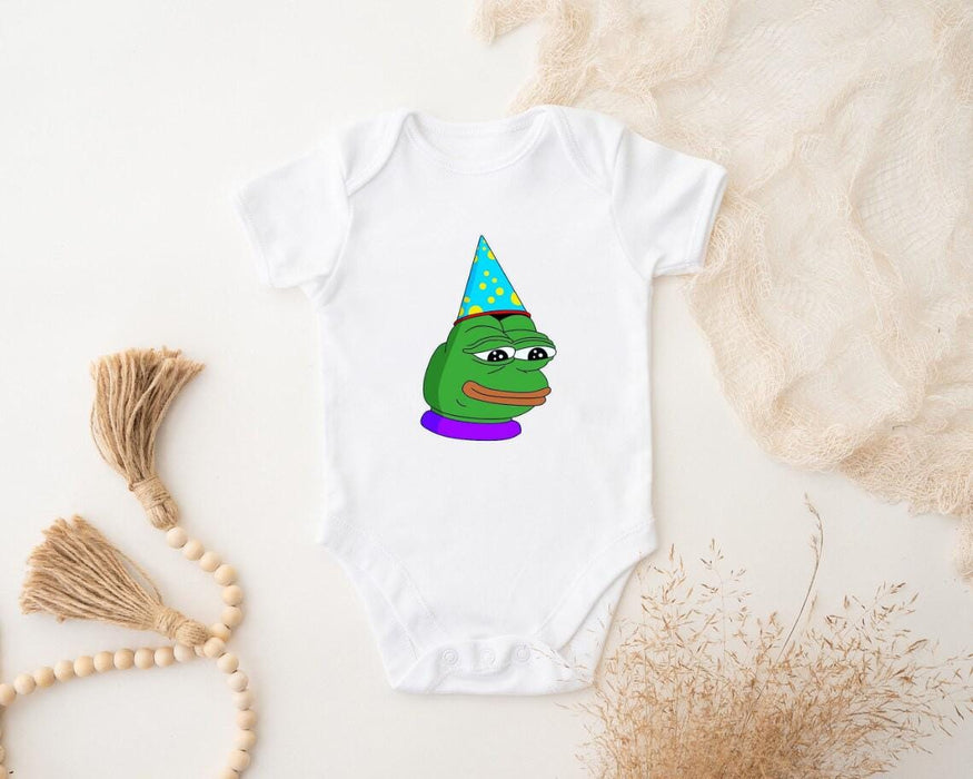 a baby bodysuit with a frog wearing a party hat
