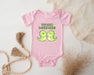 a pink baby bodysuit with two green birds on it