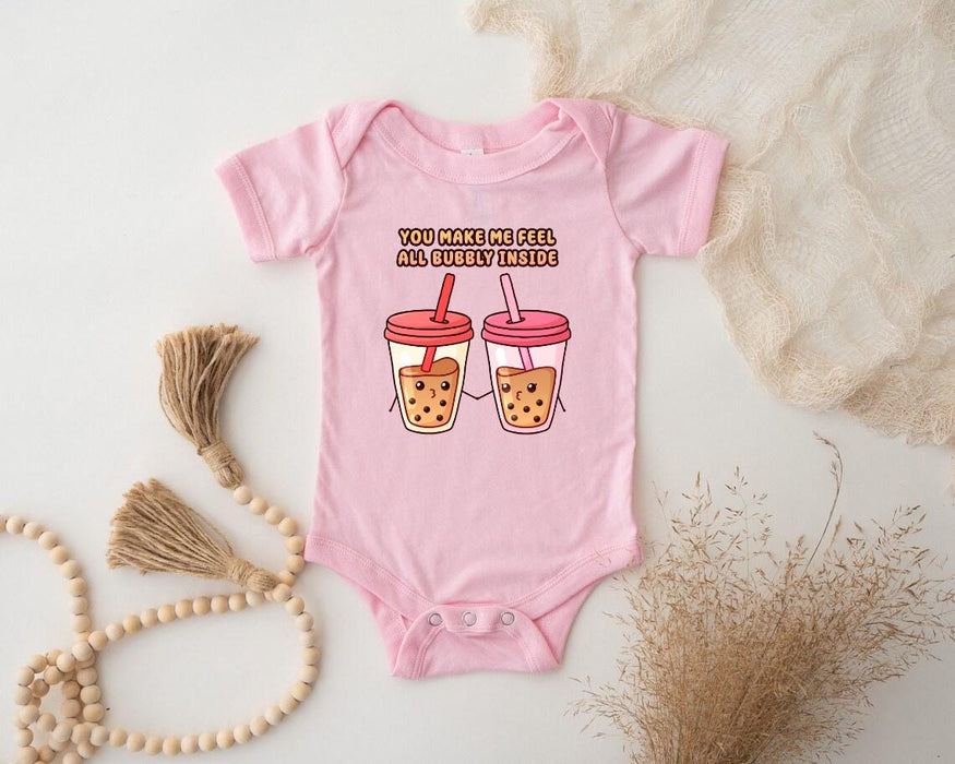 a baby bodysuit with two cups of iced coffee on it