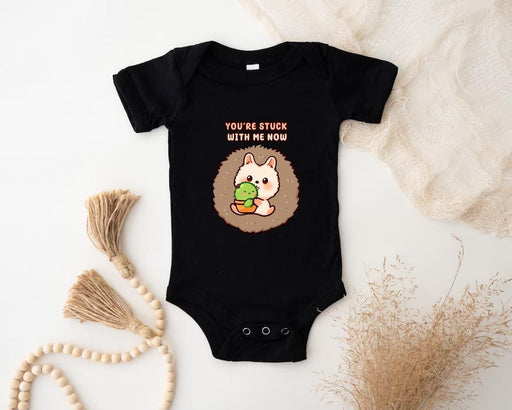 a baby bodysuit with a picture of a hedge holding a ball