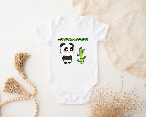 a baby bodysuit with a panda holding a cactus