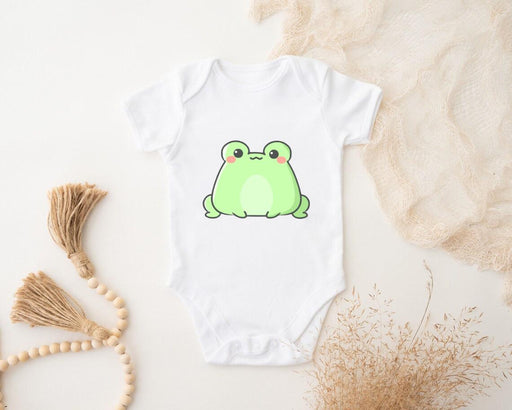 a white bodysuit with a green frog on it