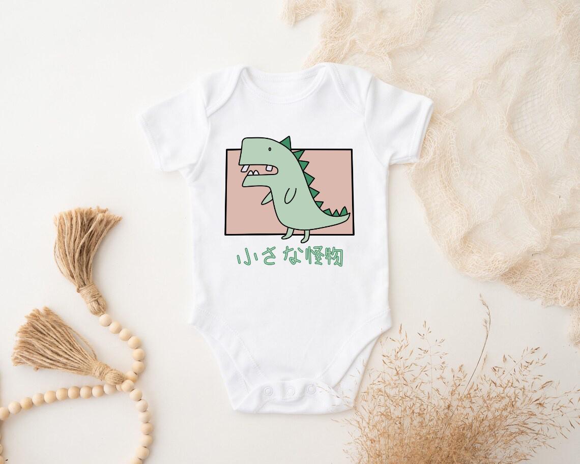 a white bodysuit with a green dinosaur on it