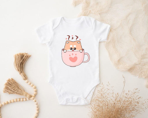 a baby bodysuit with a cat in a cup on it