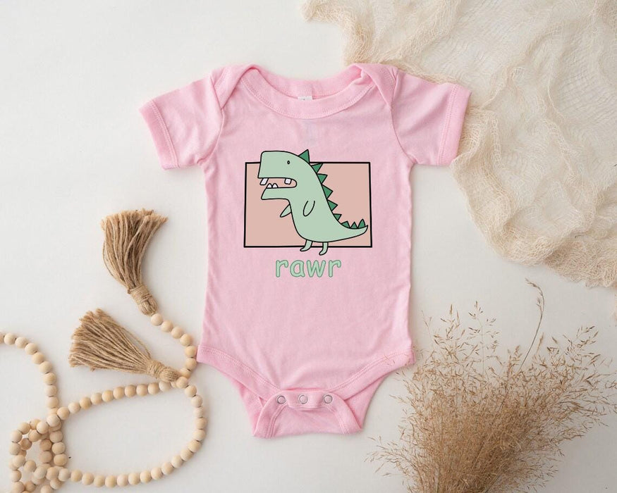a pink baby bodysuit with a green dinosaur on it