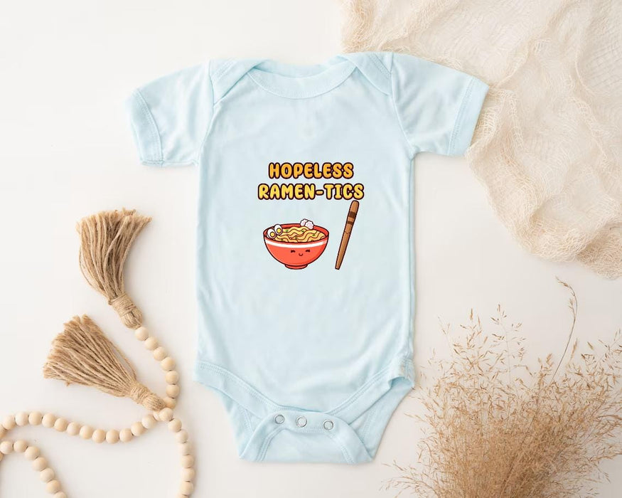 a baby bodysuit with a picture of a bowl of food and a tassel