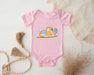 a pink baby bodysuit with a cartoon cat on it