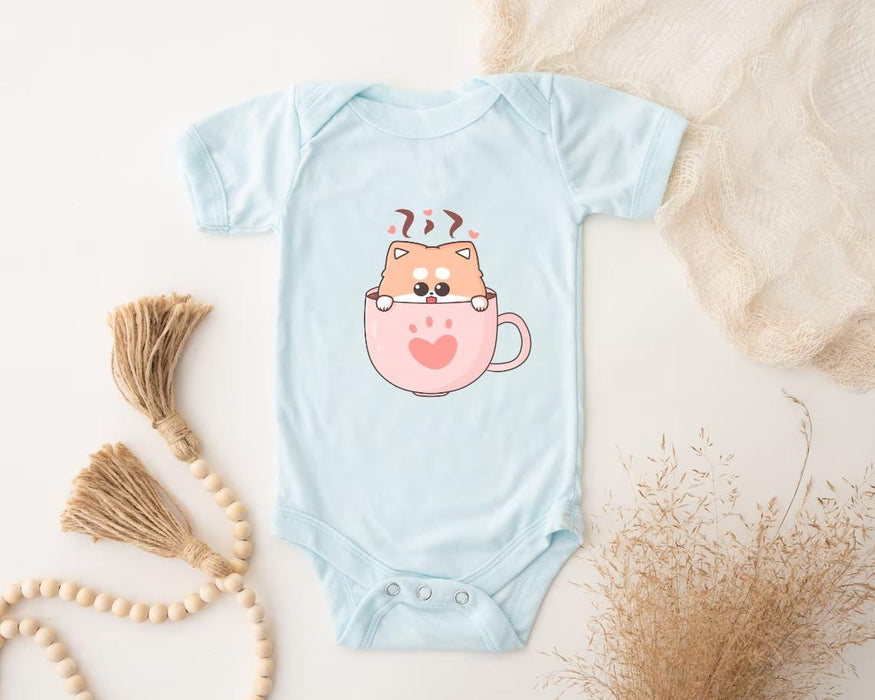 a baby bodysuit with a cat in a cup on it