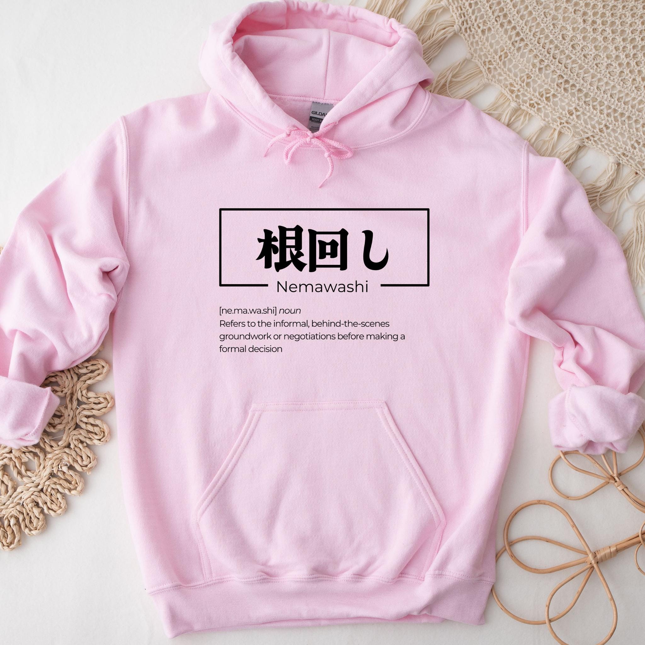 a pink hoodie with japanese characters on it