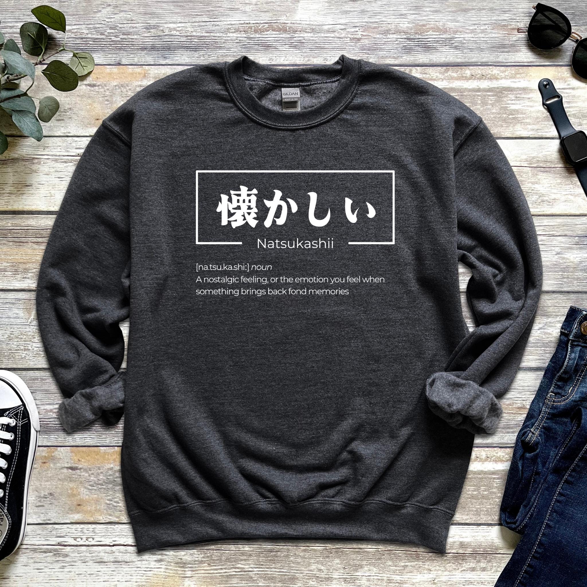 a sweater with japanese characters on it next to a pair of jeans
