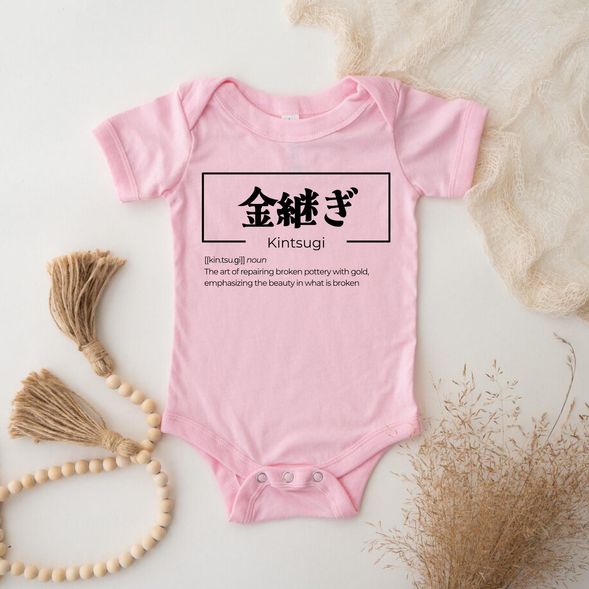 a baby bodysuit with chinese characters on it