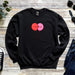 a black sweater with two red balloons on it