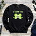 a black sweatshirt with two green dinosaurs saying i roar you