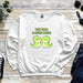 a white sweatshirt with two green dinosaurs on it