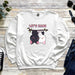 a sweatshirt with two dogs hanging on a tree branch