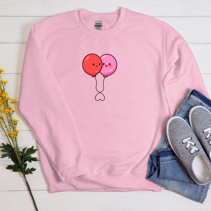 a pink sweatshirt with two balloons drawn on it