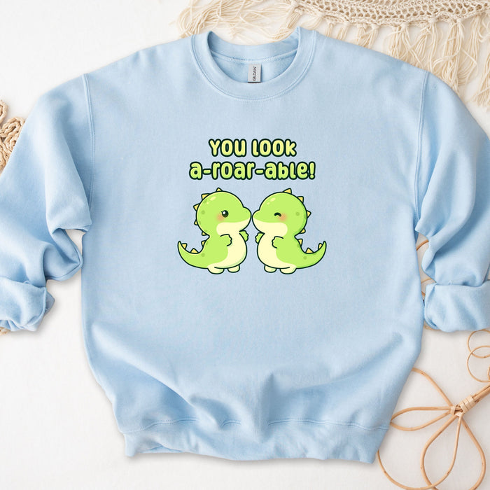 a blue sweatshirt with two green dinosaurs on it