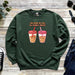 a green sweatshirt with two cups of coffee on it