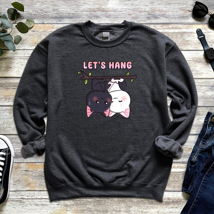 a sweatshirt with two cats hanging on a tree branch