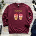 a maroon sweatshirt with two cups of coffee on it