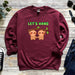 a maroon sweatshirt with two slots hanging on a tree branch