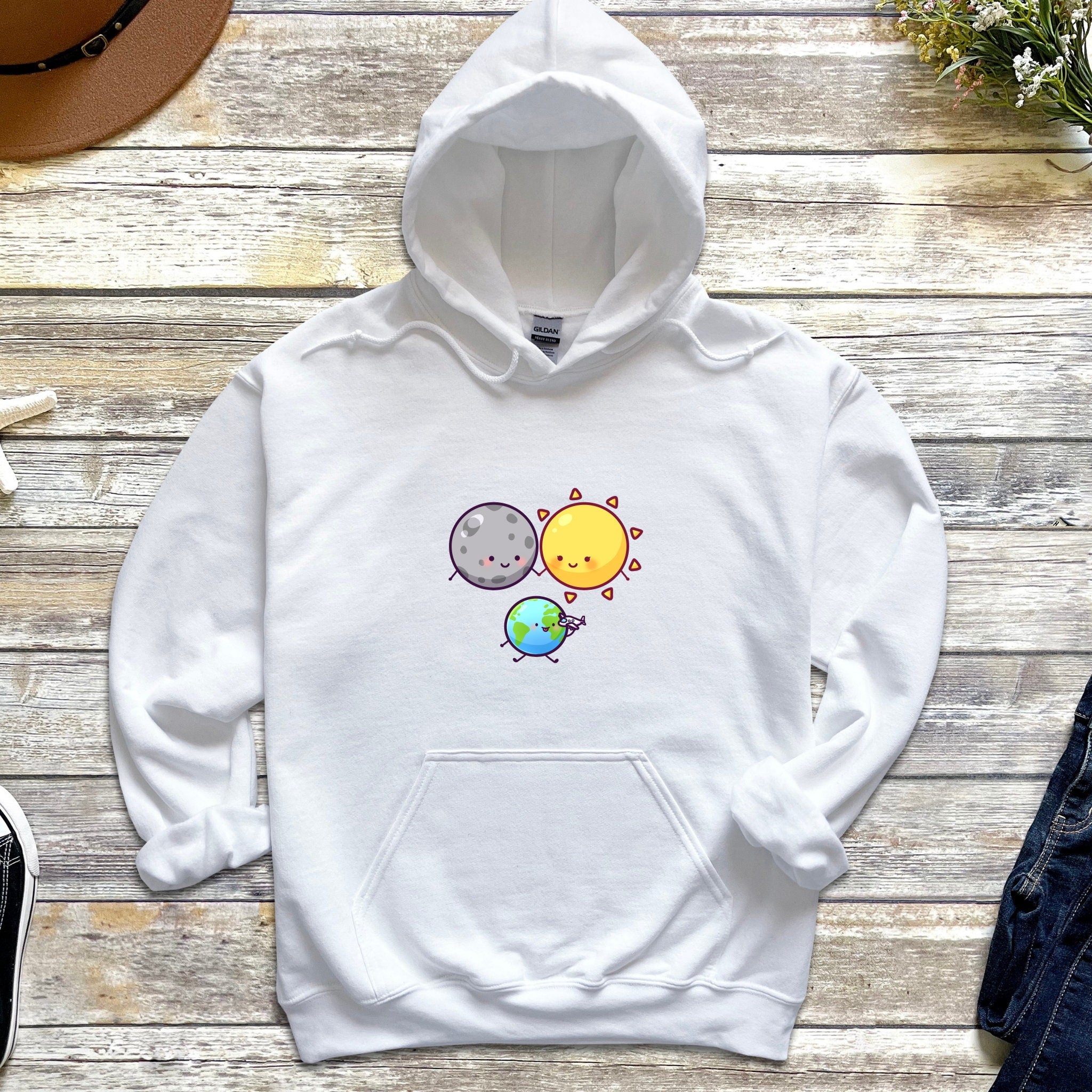 a white hoodie with an image of a sun and a planet on it