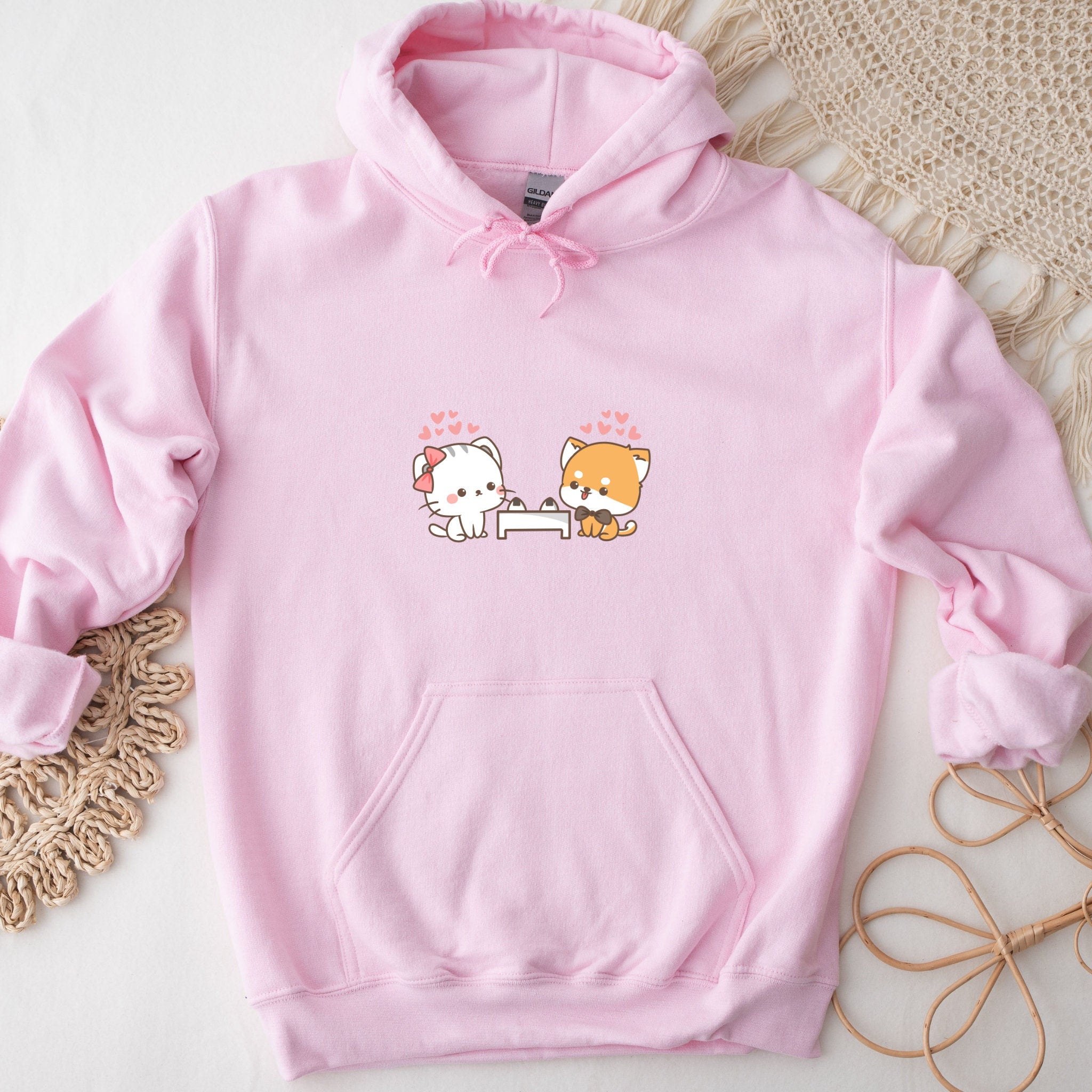 a pink hoodie with two cats on it