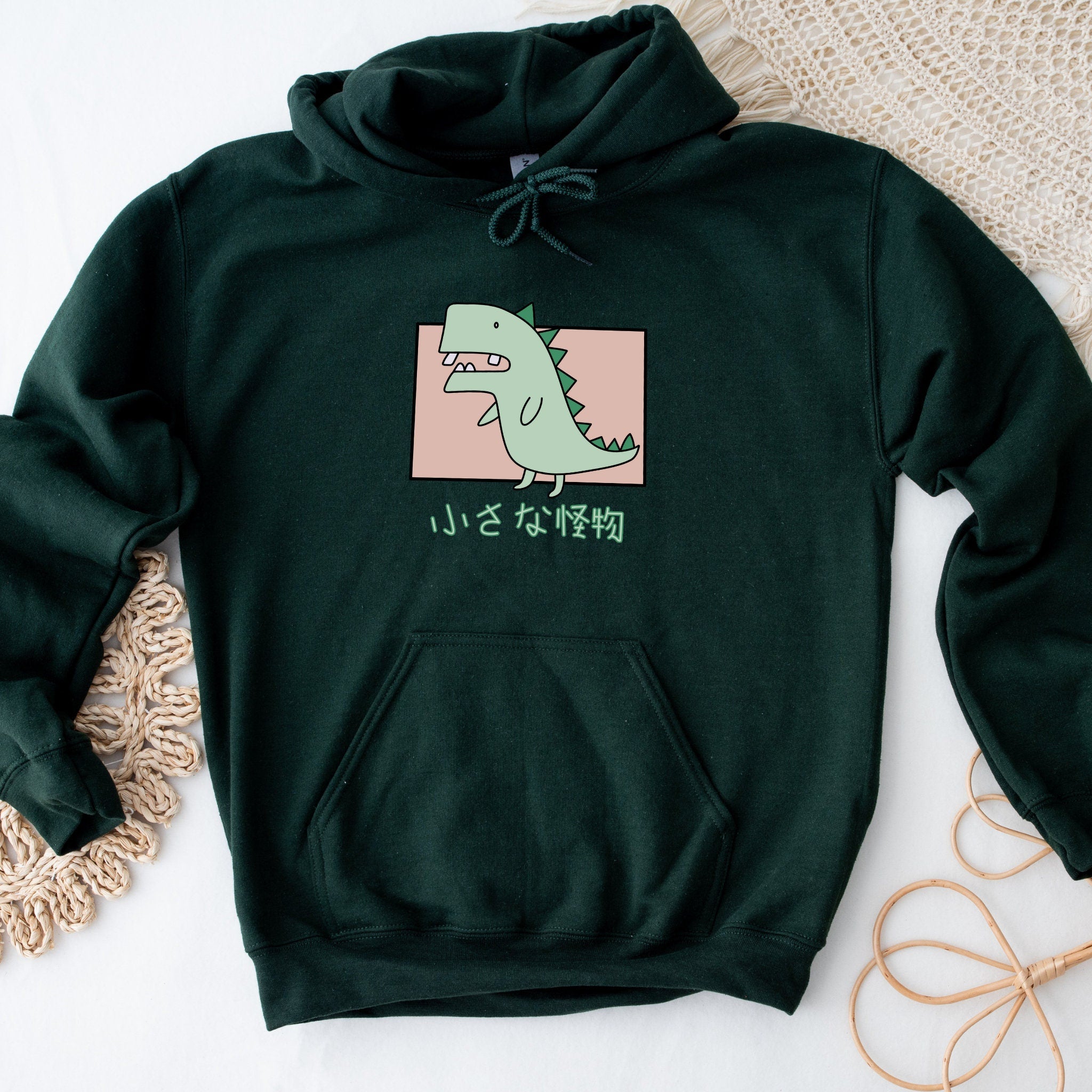 a green hoodie with a picture of a dinosaur on it