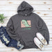 a gray hoodie with a green dinosaur on it