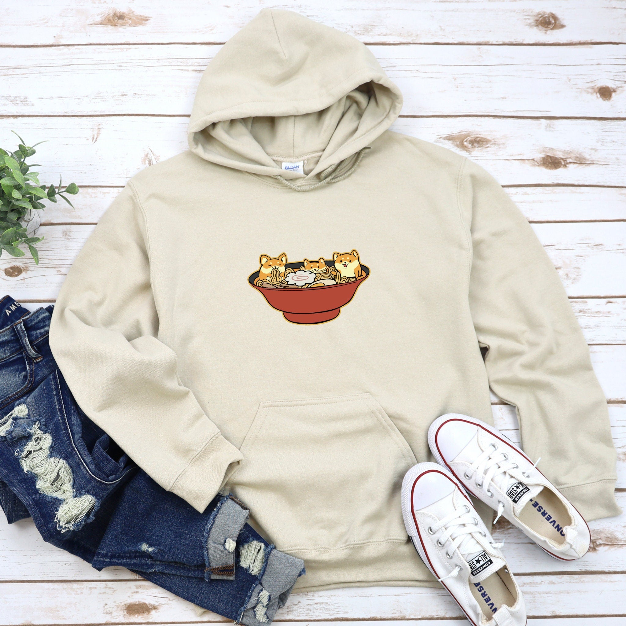 a sweatshirt with a picture of three cats in a bowl on it